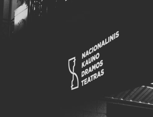 Illuminated signage of Kaunas Drama Theatre in black and white low angle shot.